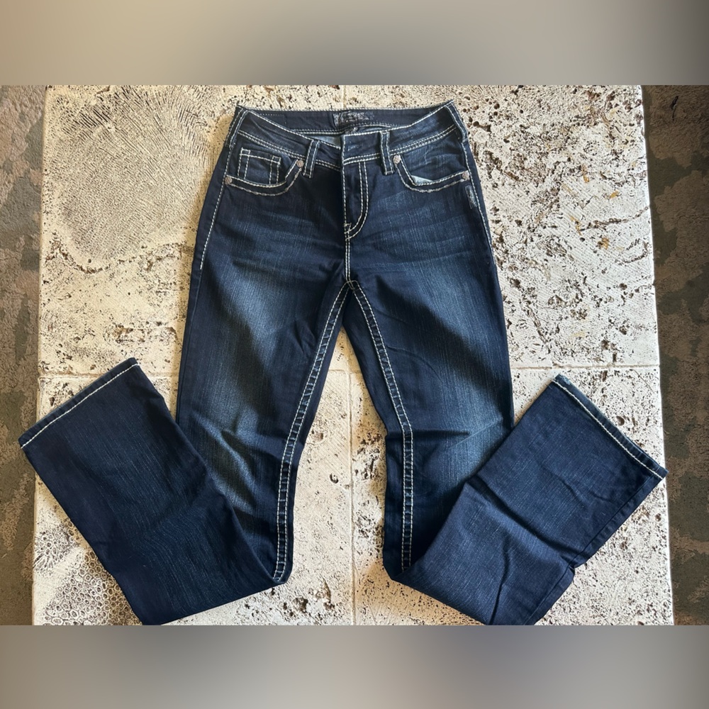 Long length boot cut jeans with white stitching and decorative pockets